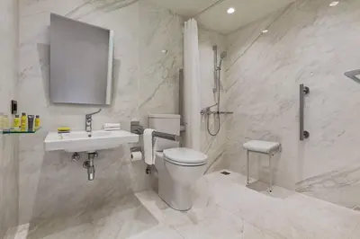 a white bathroom with a toilet and a sink at Athens Marriott Hotel in Athens