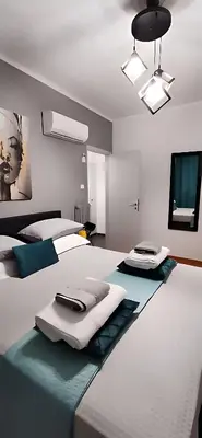 a bedroom with two beds with towels and a television at Elegant Seaside 2 Floor Apartment in Athens