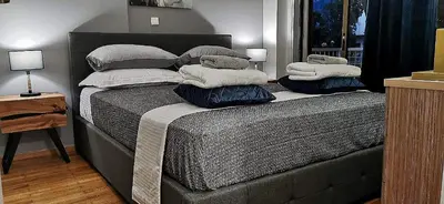 a bedroom with a bed with pillows on it at Elegant Seaside 2 Floor Apartment in Athens