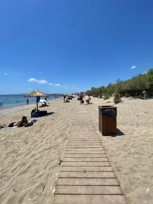 a wooden path on a beach with people on it at Elegant Seaside 2 Floor Apartment in Athens
