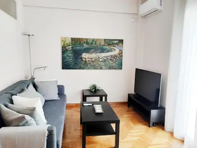 a living room with a couch and a tv at Koukaki cozy apartment 5 minutes to metro in Athens