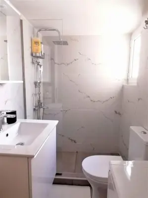 a white bathroom with a sink and a toilet at Koukaki cozy apartment 5 minutes to metro in Athens