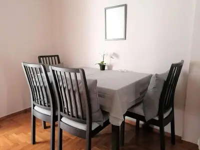 a dining room table with four chairs with a white table cloth at Koukaki cozy apartment 5 minutes to metro in Athens