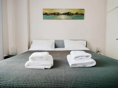 a bedroom with a bed with white towels on it at Koukaki cozy apartment 5 minutes to metro in Athens