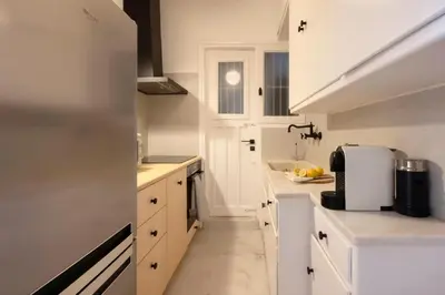 a white kitchen with white cabinets and a sink at Meliti Apartment in Plaka in Athens