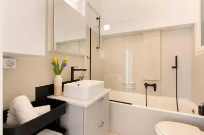 a white bathroom with a sink and a tub at Meliti Apartment in Plaka in Athens
