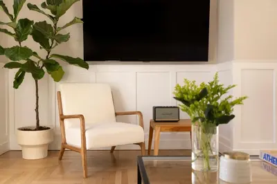 a living room with a chair and a tv on a wall at Meliti Apartment in Plaka in Athens
