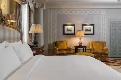 a bedroom with a large bed and two chairs at Hotel Grande Bretagne, a Luxury Collection Hotel, Athens in Athens