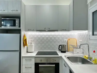 a white kitchen with a sink and a stove at near Acropolis new 2 bedrooms apt in Koukaki in Athens