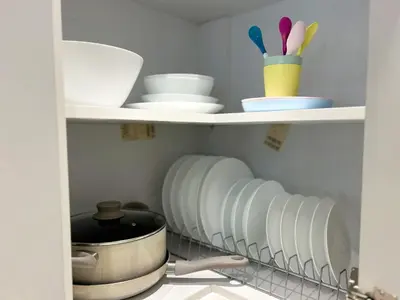 a kitchen pantry with dishes and bowls on shelves at near Acropolis new 2 bedrooms apt in Koukaki in Athens