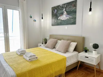 a bedroom with a bed with a yellow blanket at near Acropolis new 2 bedrooms apt in Koukaki in Athens