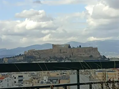 a view of the acropolis of athens from a city at Full Acropolis View Apartment in Athens
