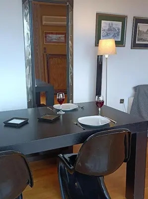 a table with two glasses of wine and two chairs at Full Acropolis View Apartment in Athens