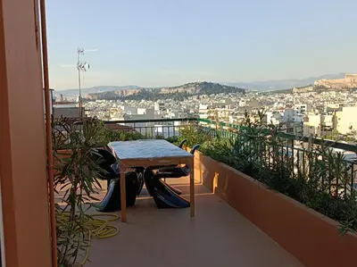 a table on a balcony with a view of a city at Full Acropolis View Apartment in Athens