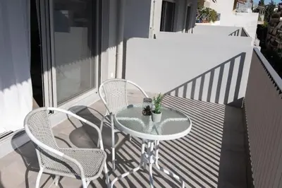 a table and two chairs on a balcony at New-built apartment close to Athens city centre (Form_E1) in Athens