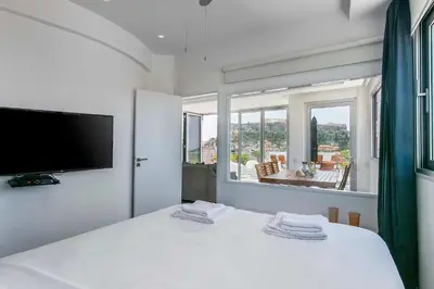 a bedroom with a white bed and a large window at Acropolis Panorama View Penthouse with Private Terraces A Contemporary Parthenon in Athens