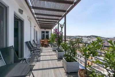 a balcony with chairs and tables on a building at Acropolis Panorama View Penthouse with Private Terraces A Contemporary Parthenon in Athens