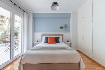 a bedroom with a large bed with an orange pillow at Homey 2BR Apartment in Cholargos by UPSTREET in Athens