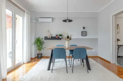 a dining room with a table and blue chairs at Homey 2BR Apartment in Cholargos by UPSTREET in Athens