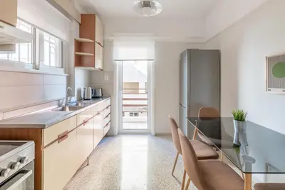 a kitchen with a stainless steel refrigerator and chairs at Homey 2BR Apartment in Cholargos by UPSTREET in Athens