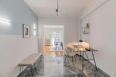 a living room with white walls and a table and chairs at Homey 2BR Apartment in Cholargos by UPSTREET in Athens