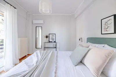 a white bedroom with a white bed and a window at Homey 2BR Apartment in Cholargos by UPSTREET in Athens