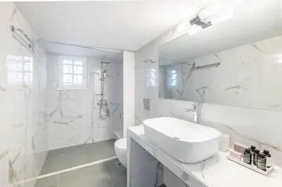 a white bathroom with a sink and a toilet at Homey 2BR Apartment in Cholargos by UPSTREET in Athens