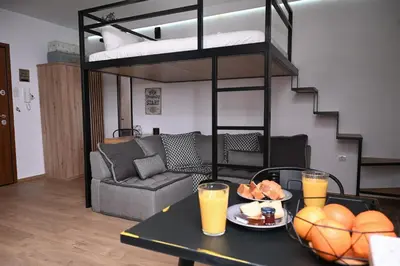 a living room with a table with orange juice and a bunk bed at Urban Loft by Neuvel in Athens
