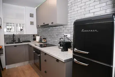 a kitchen with a black refrigerator and a white brick wall at Urban Loft by Neuvel in Athens