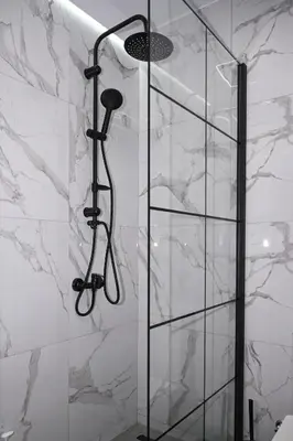 a shower in a bathroom with marble walls at Urban Loft by Neuvel in Athens