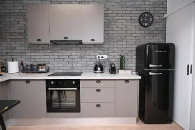 a kitchen with white cabinets and a black refrigerator at Urban Loft by Neuvel in Athens