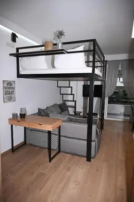 a loft bed with a couch and a table in a room at Urban Loft by Neuvel in Athens