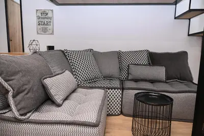 a living room with a gray couch and a table at Urban Loft by Neuvel in Athens