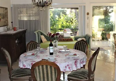 a dining room with a table with a bottle of wine at Athens Riviera coast apartment in Athens