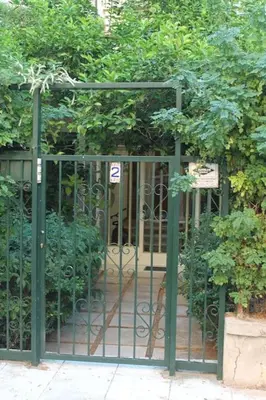 a green gate with a bunch of plants behind it at Athens Riviera coast apartment in Athens