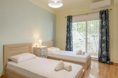 two beds in a room with a window at A perfect spot in Athens