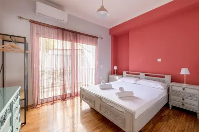 a bedroom with a white bed and a red wall at A perfect spot in Athens