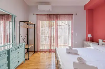 a bedroom with pink walls and a large bed and a dresser at A perfect spot in Athens