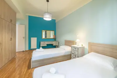 a bedroom with two beds and a blue wall at A perfect spot in Athens