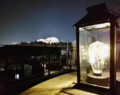 a glass lantern on a balcony at night at A perfect spot in Athens