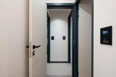 a hallway with a door with a sign on it at Nema Hotel Athens in Athens