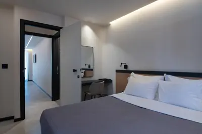 a bedroom with a bed and a desk with a chair at Nema Hotel Athens in Athens