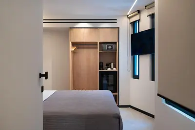 a small bedroom with a bed and a tv at Nema Hotel Athens in Athens