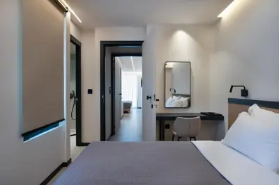 a bedroom with a bed and a desk and a mirror at Nema Hotel Athens in Athens