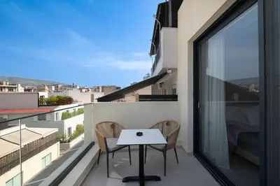 a balcony with a white table and chairs on it at Nema Hotel Athens in Athens