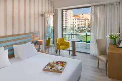 a hotel room with a bed with a tray of food on it at Athens Tiare by Mage Hotels in Athens