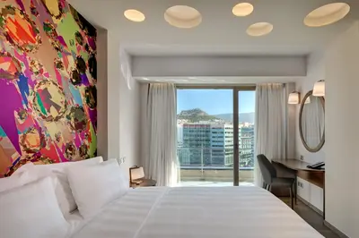a hotel room with a bed and a window at Athens Tiare by Mage Hotels in Athens