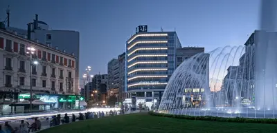 a large glass building in a city at night at Athens Tiare by Mage Hotels in Athens