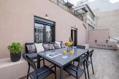a patio with a table and chairs and a couch at Exarcheia Vibe Penthouse 1 in Athens