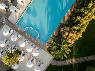 an overhead view of a swimming pool with palm trees at Plaza Resort in Anavissos
